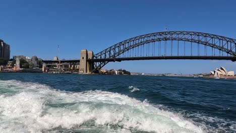 Schwenk-über-Die-Sydney-Harbour-Bridge-Und-Das-Opernhaus-Unter-Blauem-Himmel