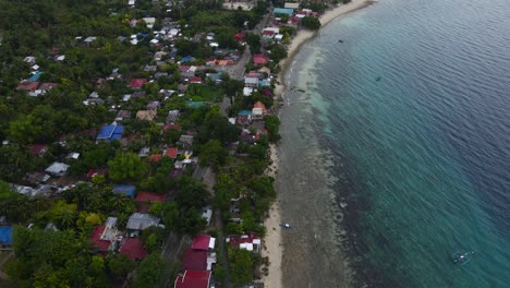 Aerial-Drone-Fly-Above-Beach-Shore-and-Village-in-Green-Philippines-Tropical-Sea-of-Cebu-Island,-Oslob