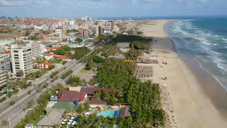 Vista-Aérea-De-La-Playa,-Palmeras-Y-La-Ciudad-Circundante,-Praia-Do-Futuro,-Ceara,-Brasil.