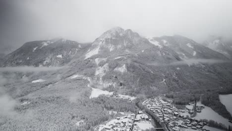 Snow-covered-Austrian-landscape,-wintertime,-cloudy,-looking-up-mountain,-Aerial,-Droneshot