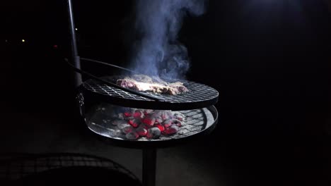 Rustikales-Barbecue-Grillfleisch-Auf-Offenem-Feuer-Kohlen-Im-Freien-Bei-Nacht-In-Zeitlupe