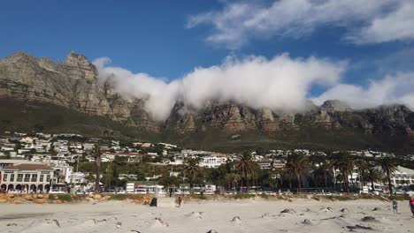 Camp's-Bay-and-cloudy-Table-Mountain-seen-from-the-beach-on-a-summer-day