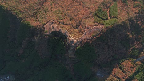 Drone-Aéreo-Gira-Sobre-Las-Ruinas-Del-Antiguo-Castillo-En-Takeda,-Hyogo-Asago-Japón-Paisaje-Verde-Y-Marrón-Del-Valle