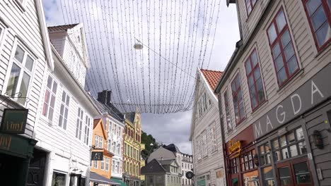 Walking-on-Street-in-Downtown-Bergen,-Norway,-Authentic-Buildings,-Bars-and-Restaurants-on-Sunny-Day-60fps