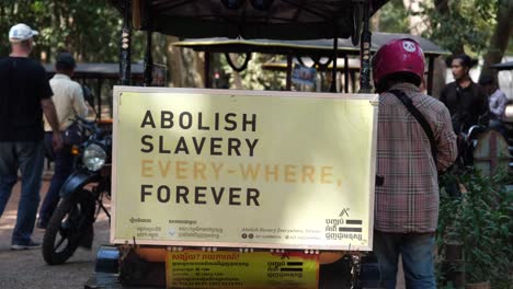 A-large-poster-displayed-along-the-public-street-bears-a-powerful-message:-"Abolish-Slavery-Everywhere,-forever