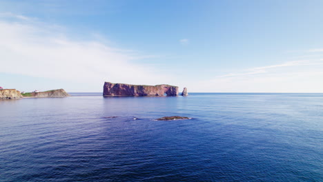 Aerial-drone-view-with-backward-tracking-of-Percé-Rock-during-a-sunny-day