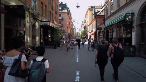 People-walk-on-a-pedestrian-street-in-the-summertime-in-central-Stockholm,-Sweden
