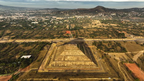 Drone-descending-toward-the-Pyramid-of-the-sun,-sunrise-in-Teotihuacan,-Mexico