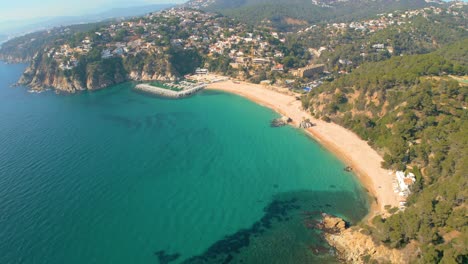 Mesmerizing-aerial-views-of-Lloret-De-Mar-and-the-secluded-paradise-of-Cala-Canyelles,-nestled-amidst-the-rugged-beauty-of-Costa-Brava