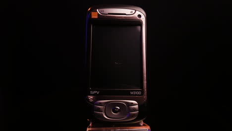 Orange-SPV-M3100-Vintage-Smartphone-Aus-Den-2000er-Jahren,-Hergestellt-Von-HTC-Für-Europäische-Telekommunikationsunternehmen,-Dreht-Sich-Aus-Nächster-Nähe