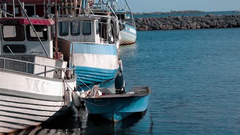Old-small-fishing-boats-sit-calmly-in-a-tiny-port-on-a-sunny-day-at-the-ocean