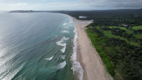 Idyllisches-Meer-Und-üppige-Vegetation-Am-Ownil-Beach-In-Byron-Bay,-NSW,-Australien-–-Luftaufnahme