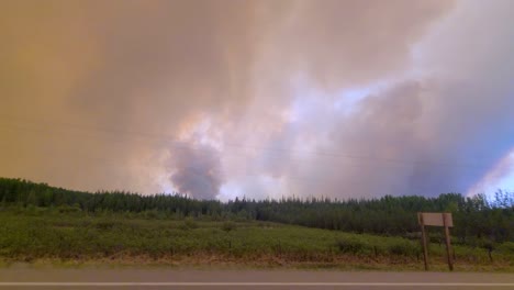 Clouds-Of-Smoke-Rising-From-Forest-Fire-Seen-From-The-Road-In-Alberta,-Canada
