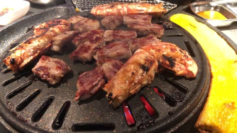 Shrimp-and-steak-being-cooked-in-a-Korean-BBQ-restaurant-in-Mong-Kok,-Hong-Kong