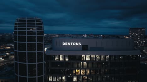 Aerial-drone-view-of-modern-office-building-with-big-windows-at-dusk