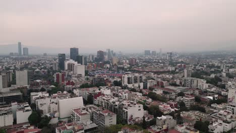 Drone-flight-over-Ciudad-de-los-Deportes-in-Mexico-City,-bullring-and-blue-stadium