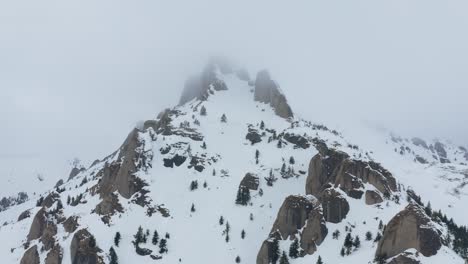 Schneebedeckte-Ciucas-Berge,-Von-Wolken-Umhüllt,-In-Einer-Ruhigen,-Unberührten-Landschaft,-Luftaufnahme