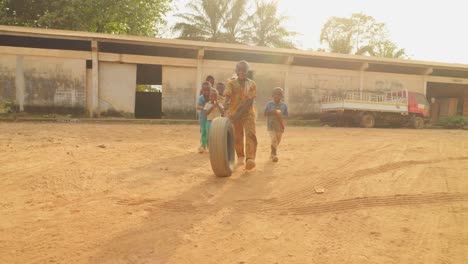 Eine-Gruppe-Von-Kindern-In-Madagaskar-Spielt-Auf-Der-Straße-Mit-Einem-Reifen