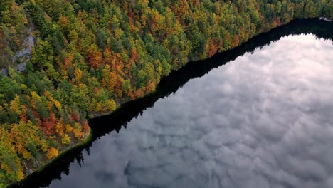 Das-Sonnenlicht-Spiegelt-Sich-Im-Ruhigen-Wasser-Des-Sees-Und-Wirft-Lange-Schatten-Von-Den-üppigen-Grünen-Bäumen,-Die-Das-Ufer-Säumen