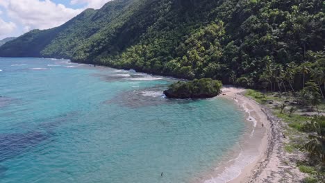 Aerial-establisher-Playa-Ermitanos-with-rural-coastline-and-bathing-tourists