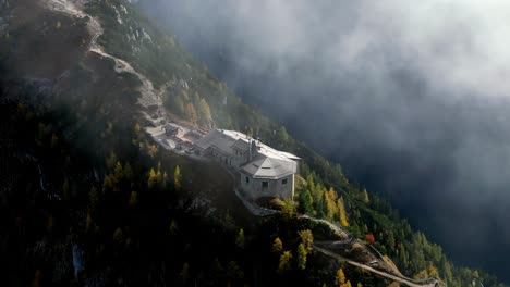 Cloudy-aerial-view-of-the-Kehlsteinhaus,-also-known-as-the-Eagle's-Nest,-perched-atop-a-rocky-outcrop-in-the-Bavarian-Alps,-Germany