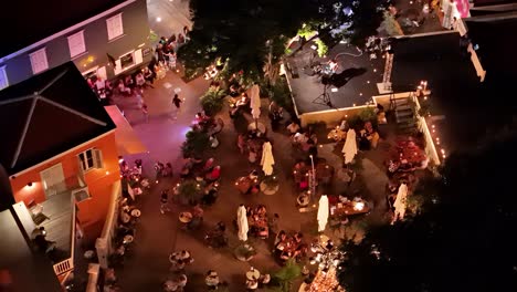 órbita-Aérea-Alrededor-De-Familias-Disfrutando-De-La-Noche-En-Un-Café-Al-Aire-Libre-En-La-Aldea-De-Kura-Hulanda-En-Otrobanda-Willemstad-Curacao