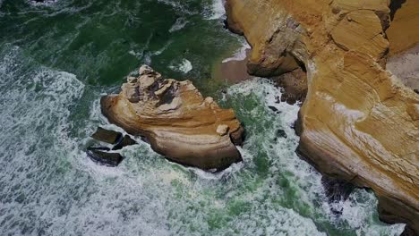 Top-Down-Tilt-View-Over-La-Catedral-Rock-with-Ocean-Waves-Crashing-Against-the-Rocks-Below,-Peru,-South-America