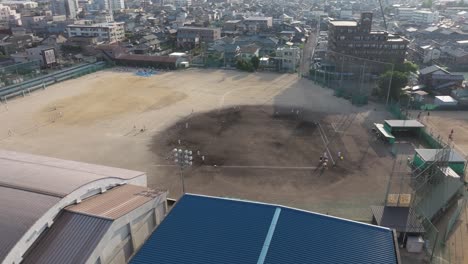 Aerial-Drone-Fly-Above-sports-stadiums,-dirt-baseball-fields,-school-in-Fukui-prefecture,-Japan-during-a-sunny-day