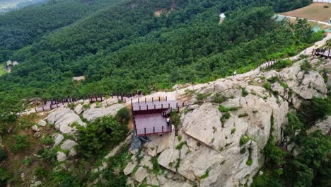 Vista-Panorámica-Aérea-Dinámica-Hacia-Adelante-De-Un-Hombre-Negro-Volando-Un-Dron-En-Weihai-Huaxia-Cheng,-China