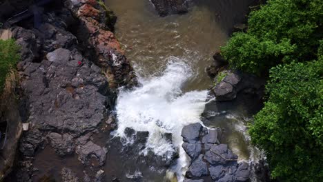 Draufsicht-Auf-Das-Wasser,-Das-In-Den-Natürlichen-Pool-Des-Tegenungan-Wasserfalls-In-Bali,-Indonesien-Stürzt