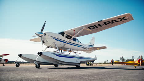 Low-angle-pan-of-shiny-Cessna-206-Stationair-amphibian-seaplane-private-aircraft-with-model-airplane