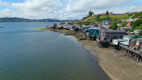 Dolly-in-flyover-of-the-coast-of-the-colorful-stilt-houses-in-Castro,-Chilo?
