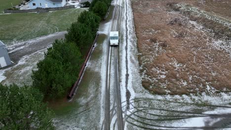 Toma-De-Drone-De-Un-Vehículo-De-USPS-Conduciendo-Por-Caminos-Rurales-Cubiertos-De-Nieve-Para-Entregar-El-Correo.