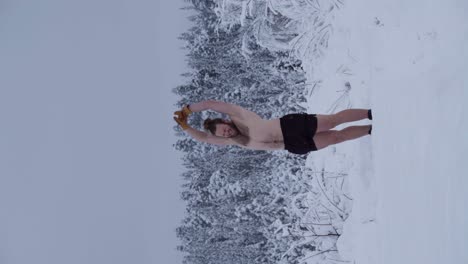 A-Man-is-Warming-Up-Before-Attempting-a-Handstand-in-the-Deep-Snow---Vertical-Shot