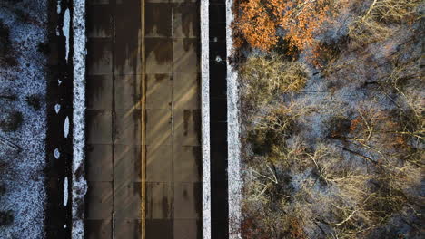 Aerial-shot-of-Mount-Sequoyah,-AR-with-a-wide-street-and-autumn-trees,-sunlight-casting-shadows