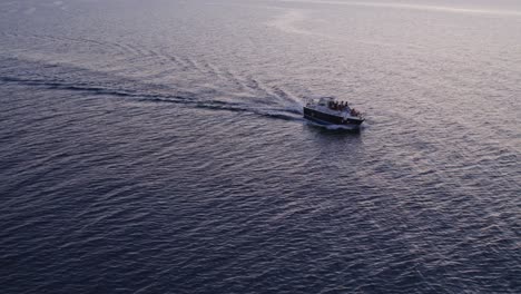 Luftaufnahme-Eines-Bootes-Auf-Ruhiger-See-Mit-Menschen-Bei-Sonnenuntergang,-Cefalu,-Sizilien,-Italien