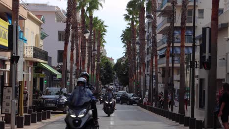 Car,-motorcycle-and-pedestrian-traffic-on-street-in-Antibes,-France
