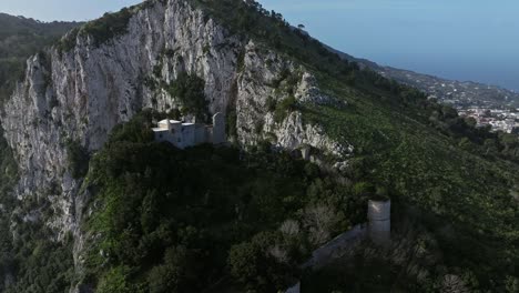 Luftaufnahme-Eines-Einsamen-Weißen-Hauses-Auf-Schroffen-Klippen-Von-Capri-Mit-Blick-Auf-Das-Meer