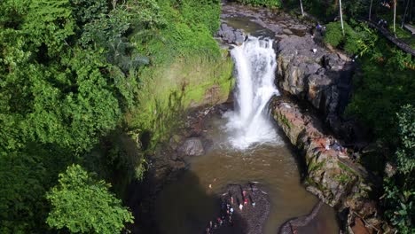 Aerial-view-of-Tourists-standing-next-to-Tegenungan-waterfall-in-BALI,-Indonesia