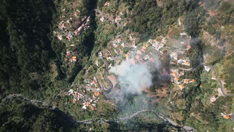 fire-and-smoke-in-a-small-village-in-a-green-valley-in-madeira,-green-forest,-landscape,-portugal,-drone,-aerial