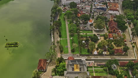Kandy-Sri-Lanka-Aerial-v14-birds-eye-view-flyover-lakeside-Temple-of-the-Tooth-Relic-and-Sacred-city,-tilt-up-capturing-downtown-cityscape-and-hillside-landscape---Shot-with-Mavic-3-Cine---April-2023
