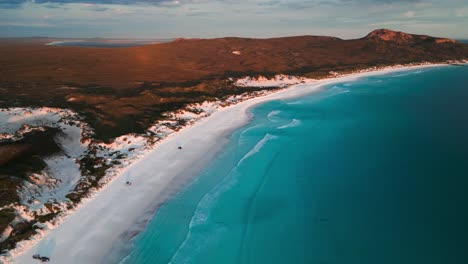 drone-shot-over-Lucky-BAy-at-sunset-in-Cape-Legrand-National-Park-with-4WD-on-the-beach,-Western-Australia