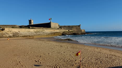 Strand-Von-Carcavelos-Mit-Der-Festung-Oder-Dem-Fort-Von-São-Julião-Da-Barra,-Dem-Größten-Und-Vollständigsten-Militärischen-Verteidigungskomplex-Im-Vauban-Stil,-Der-In-Portugal-Noch-Erhalten-Ist