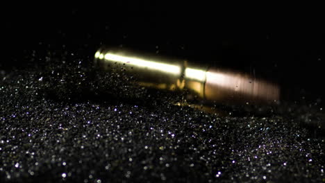 Slow-motion-shot-of-cartridge-firearms-bullets-falling-on-gunpowder-dust,-macro