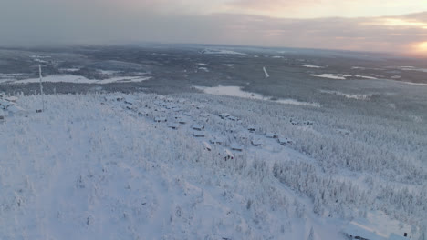 Aerial-view-around-a-cabin-town-on-top-of-a-Iso-Syote-fell,-sunrise-in-Finland