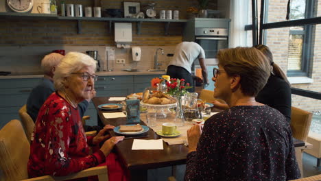 Retirement-home-scene-with-caretakers-and-elderly-people-talking-in-lunchroom