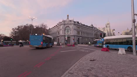 Einspielung-Sonnenaufgang-Madrid-Banco-De-Espana-Bank-Von-Spanien-Auf-Dem-Cibeles-Platz-Mit-Farbenfrohen-Schönen-Wolken-Und-Morgendlichem-Berufsverkehr