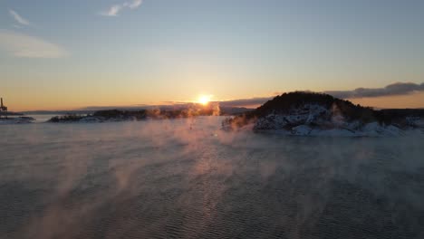 Goldener-Sonnenuntergang-Am-Horizont-In-Der-Nähe-Von-Bjorvika,-Oslo-Mit-Nebel,-Der-über-Dem-Wasser-Schwebt
