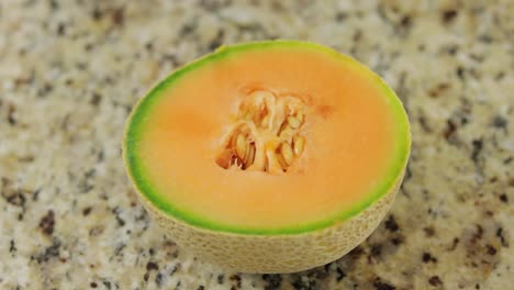 Gesunde-Halbe-Melone-Auf-Der-Marmorierten-Oberfläche-In-Nahaufnahme