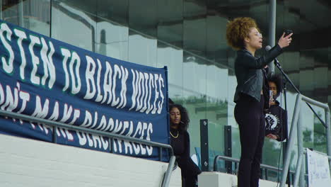 African-American-woman-protesting-for-change-using-her-voice,-talking-through-microphone,-black-lives-matter-rally